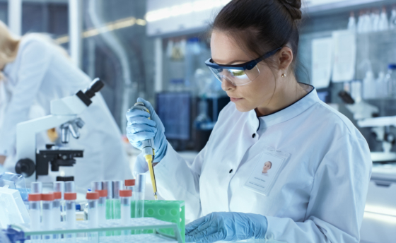 Female Research Scientist Uses Micropipette Filling Test Tubes i