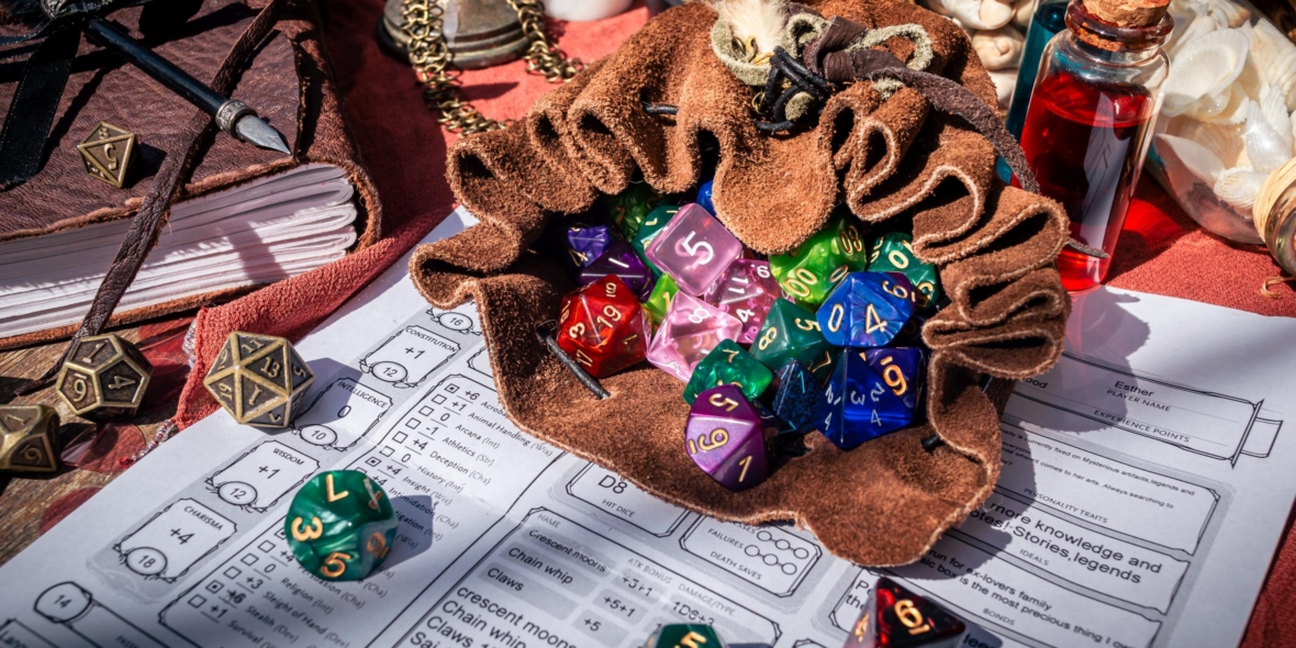 A leather dice bag filled with dice on a character sheet