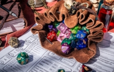 A leather dice bag filled with dice on a character sheet