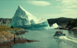 "Fishing boat sailing through a narrow waterway flanked by rocky shores and evergreen trees, with a massive iceberg floating ahead, under a partly cloudy sky."